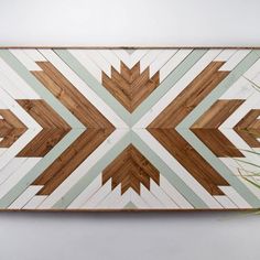 a wall hanging made out of wood with an arrow design on the top and bottom