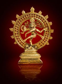 a golden statue with an intricate design on it's face and arms, in front of a red background