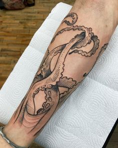 a man's arm with an octopus tattoo on it