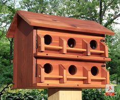 a wooden bird house with multiple holes in it