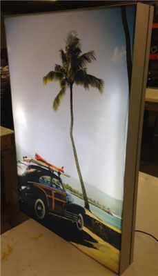 an image of a car with surfboards on the roof parked in front of a palm tree