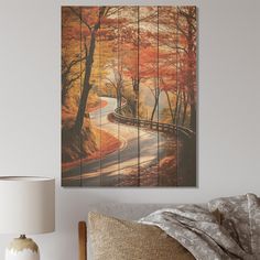 a bedroom scene with focus on the bed and wall art that has trees painted on it