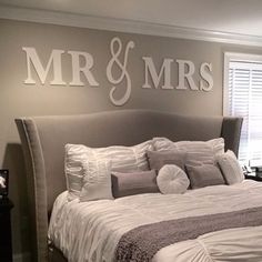 a large bed sitting in a bedroom under a mr and mrs sign