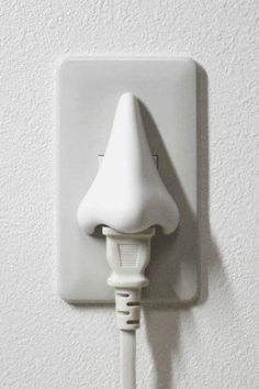 an electric outlet plugged into a wall with a white cord attached to the outlet