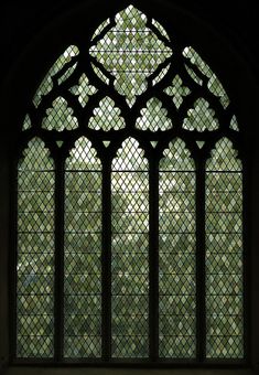 an old stained glass window with trees in the background