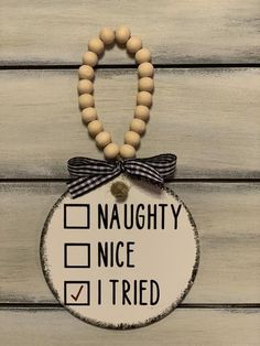 a wooden beaded necklace with a check mark on the front and an inscription that says,'naught nice i tried '