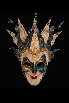 a mask with blue and gold designs on it's face, against a black background