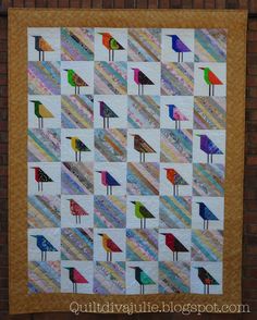 a quilted wall hanging with different colored birds on it's sides and one bird standing in the middle