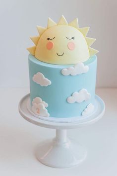 there is a cake that looks like the sun in the sky with clouds on it