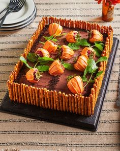 there is a chocolate cake with orange flowers on the top and green leaves in the middle