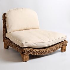 a wicker chaise lounge chair with cushion on white background in front of wall