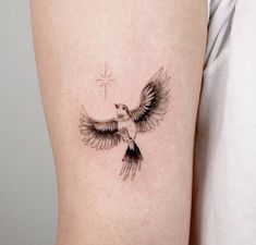 a small bird tattoo on the right side of the thigh, with a star in the sky above it