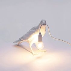 a bird lamp with a light bulb attached to it's body and its legs