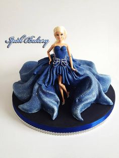 there is a cake that looks like a barbie doll on top of a blue dress