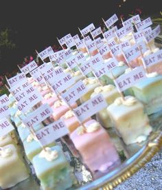 many different types of marshmallows are on a tray with small signs attached to them