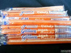 five rolls of candy are wrapped in plastic wrappers on a black tablecloth background