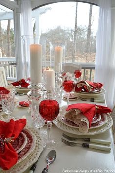 the table is set with red napkins and candles