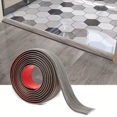 there is a roll of tile on the floor next to a red and white tape