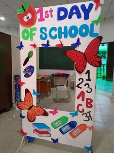 a sign that says 1st day of school in front of a blackboard with butterflies