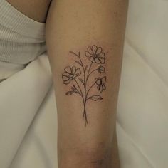 a small flower tattoo on the arm