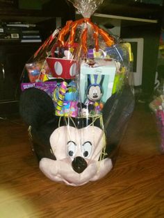 a stuffed animal sitting on top of a wooden table next to a basket filled with toys