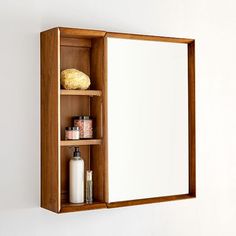 a wooden medicine cabinet with mirror and soap dispenser on it's shelf