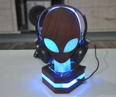 an alien head with glowing blue eyes and headphones on top of a white table