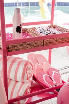 pink and white towels, flip flops, and water bottle on a beach cart