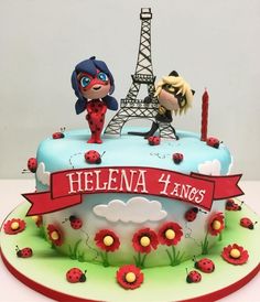 a cake decorated with the eiffel tower and ladybug figurines