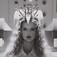 a woman with long curly hair and a crown on her head is shown in black and white