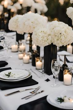 the table is set with white flowers and candles