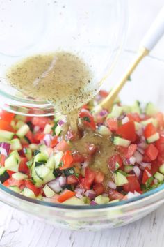 a glass bowl filled with chopped vegetables and dressing