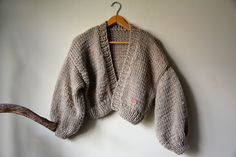 "Chunky Knit Cardigan, Cropped Chunky Sweater, Hand Knitted Jumper, Open Style Cardigan, Chunky Jacket, Sweater Women's Cozy, Beige Sweater Loose fit One size Oversized Color beige Lenght 16,53\" (42cm) Width 22\" (56cm) Lenght of sleeve 15,74\" (40cm) This warm cardigan is knitted by me from a thick yarn 5% Mohair, 10% Wool 85% Premium Acrylic Handmade. Clean by hand in very delicate detergent. Dry flat. Standard shipping is 10-16 days usually FAST SHIPPING Shipping via FedEx is also possible - Slouchy Cozy Cropped Sweater For Fall, Cozy Slouchy Cropped Sweater For Fall, Cozy Chunky Knit Cropped Sweater, Slouchy Chunky Knit Cropped Sweater For Fall, Oversized Knitted Cropped Sweater For Layering, Cozy Knit Cropped Sweater For Fall, Cozy Chunky Long Sleeve Sweater, Cozy Slouchy Cropped Sweater For Winter, Slouchy Chunky Knit Cropped Sweater