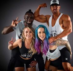 three people posing for a photo with one woman and the other man showing off their muscles