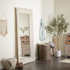 there is a mirror, basket and other items on the floor in this living room