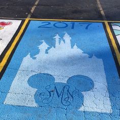 a mickey mouse sign painted on the sidewalk