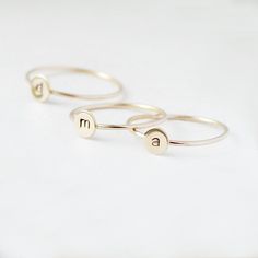 One gold letter ring. Personalize a gift she'll treasure with our gold initial ring. An adorably petite initial, imprinted on a 14k gold filled disk - paired with a super skinny (1mm) gold filled band - creates the perfect stacking ring, customized with your monogram. Lovely as a stand alone. Also sits beautifully with multiple initials stacked or our hammered gold stacking ring bands. This gold initial ring arrives custom made to order in your size hand stamped with the letter of your choice. A Gold Sterling Silver Initial Stackable Ring, Gold Sterling Silver Stackable Initial Ring, Minimalist Monogram Initial Ring, Simple Stackable Initial Ring, Simple Personalized Gold Stackable Rings, Dainty Personalized Initial Ring For Promise, Adjustable Monogram Initial Ring For Everyday, Dainty Personalized Initial Promise Ring, Gold Stackable Rings With Initials