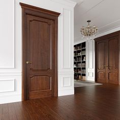 an empty room with wood floors and white walls, two doors open to the library