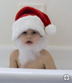 a baby wearing a santa hat and sitting in a bathtub with the caption buongigono