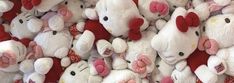 many white teddy bears with red bows on their heads and ears are piled up together