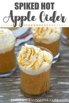 two glasses filled with spiked hot apple cider drink on top of a wooden table