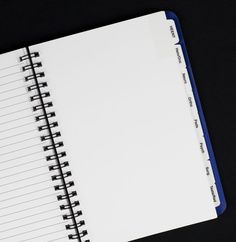 an open spiral notebook sitting on top of a table