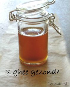 a glass jar filled with liquid sitting on top of a piece of paper that says is ghee gezond?