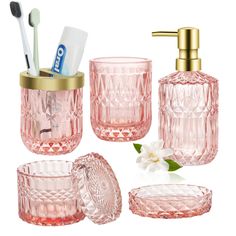 pink glass bathroom accessories including toothbrushes, soap dispenser and cup