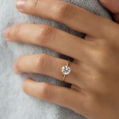 a woman's hand with a diamond ring on it