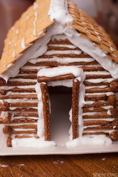 a gingerbread house with white icing and cinnamon sprinkles on top