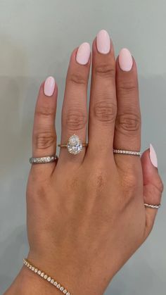 a woman's hand with three different rings on her fingers and one is holding the other