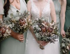 a group of women standing next to each other holding bouquets with flowers on them