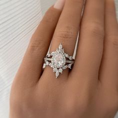 a woman's hand with a diamond ring on top of her finger and an engagement band