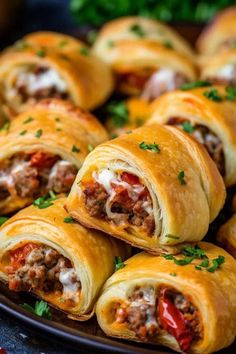 several sausage rolls on a plate with parsley sprinkled around the edges, ready to be eaten